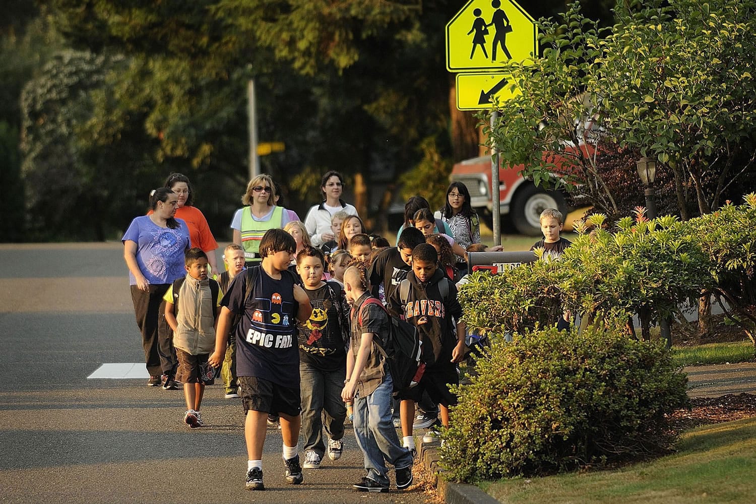 Alex Beltran-Villa, 10, fifth-grade student at Sacajawea Elementary School, left, leads a group of Walking School Bus participants through his Hazel Dell neighborhood.