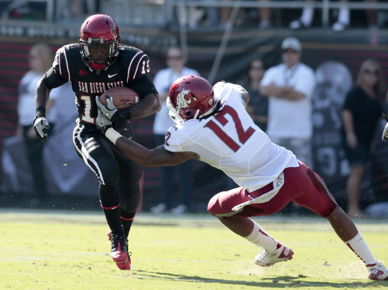 San Diego State running back Ronnie Hillman, left, gets past the tackle of Washington State's C.J.