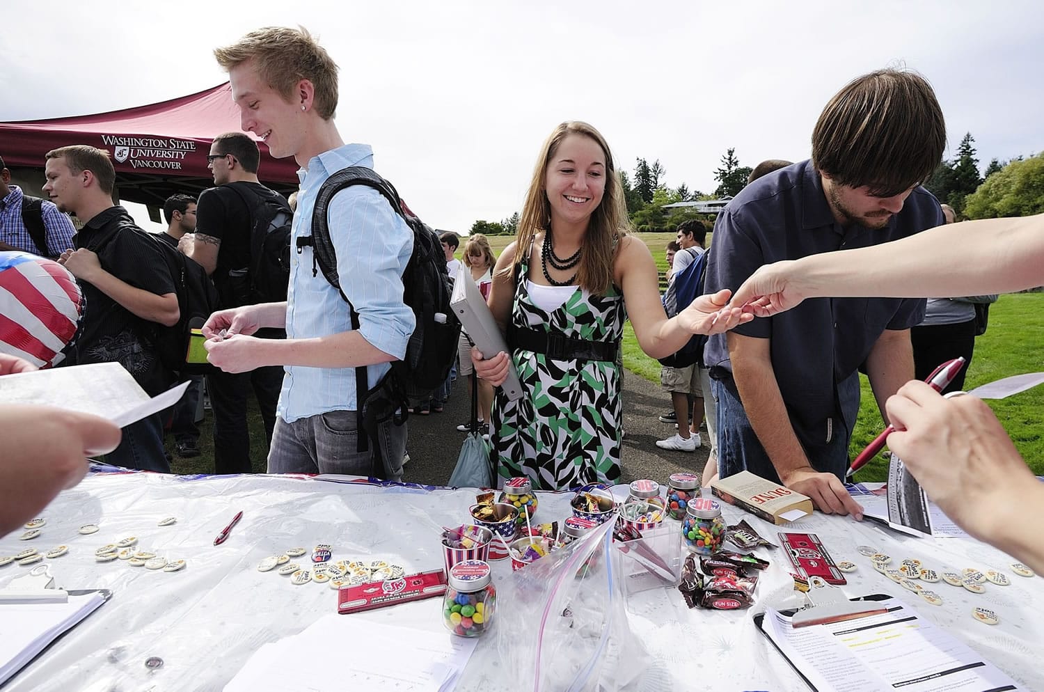 Washington State University Vancouver students Mackenzie Spray, 20, from left, Stephanie Wiese, 19, and Jon Elias, 20, register to vote and sign pledge cards at a voter pledge drive Thursday on the WSUV campus.