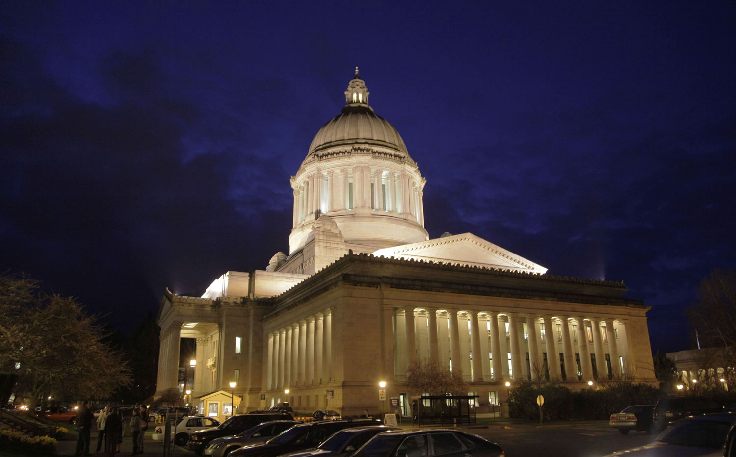 The Washington state Capitol is lit against a late-evening sky in Olympia.