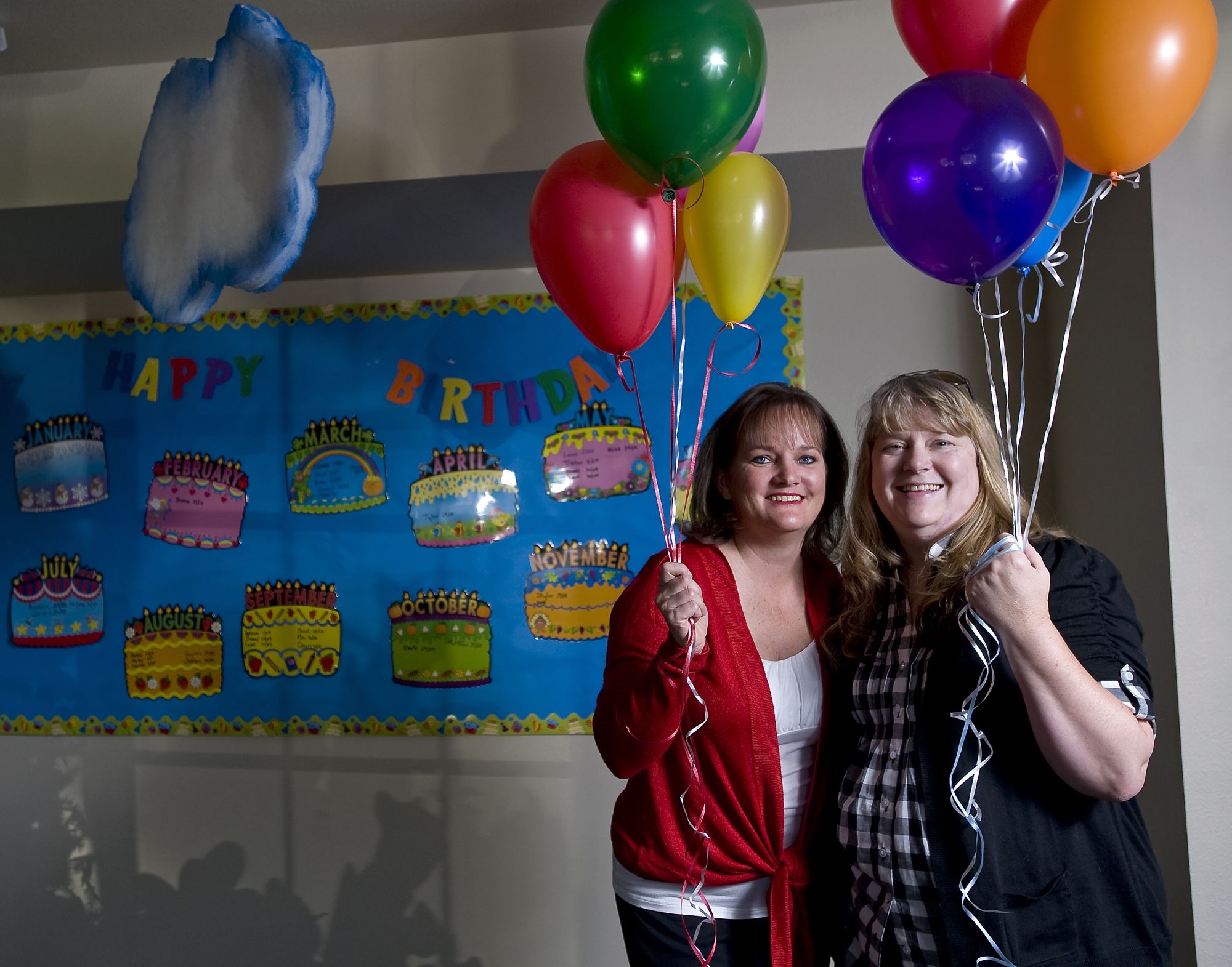 Emily Donaldson, left, and Karen Mallory hold balloons Friday at Meadowglade Seventh-day Adventist Church. The Battle Ground women, both cancer survivors, created the nonprofit, Celebrate Me Foundation.