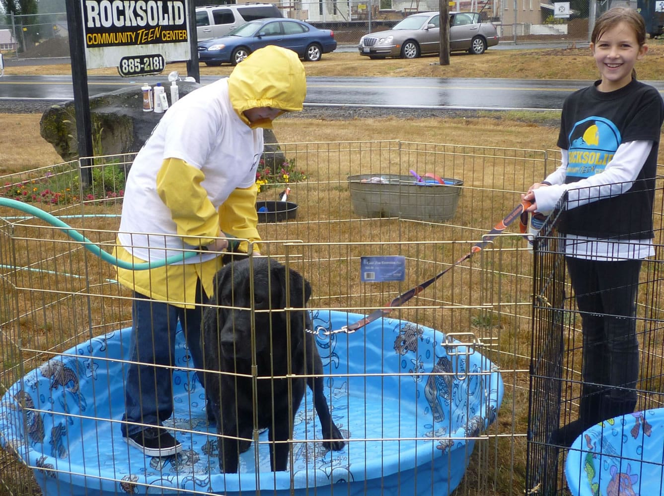 Brody Buffum, 11, left, and Vika Crossland, 10, wash a dog during the Rocksolid Community Teen Center Pet Fest.