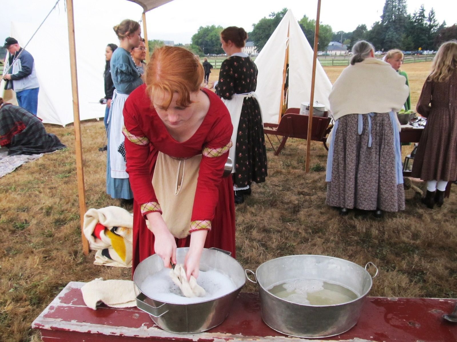 Emily Coder of Battle Ground washes dishes during Fort Vancouver National Historic Site's Campfires and Candlelight.