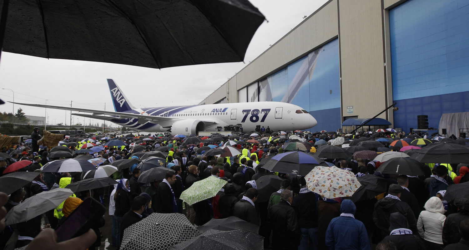 Attendees under umbrellas view a Boeing 787 airplane during a delivery celebration Monday in Everett.