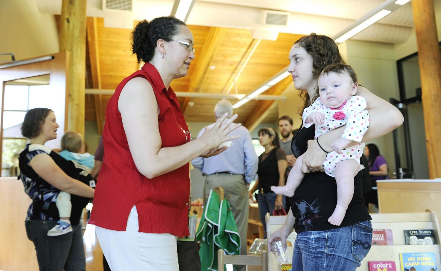 Desiree de Monye, left, talks with her daughter Emily de Monye -- who holds her own 3-month-old daughter, Charlotte de Monye -- as they tour the Oliva Family Early Learning Center after Thursday's dedication at Clark College.