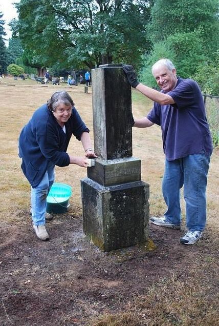 Doris Bishop and Jim Williams from The Church of Jesus Christ of Latter-day Saints Fairway Village Ward scrub a cemetery monument at the Fisher Cemetery during the church's Day of Service.
