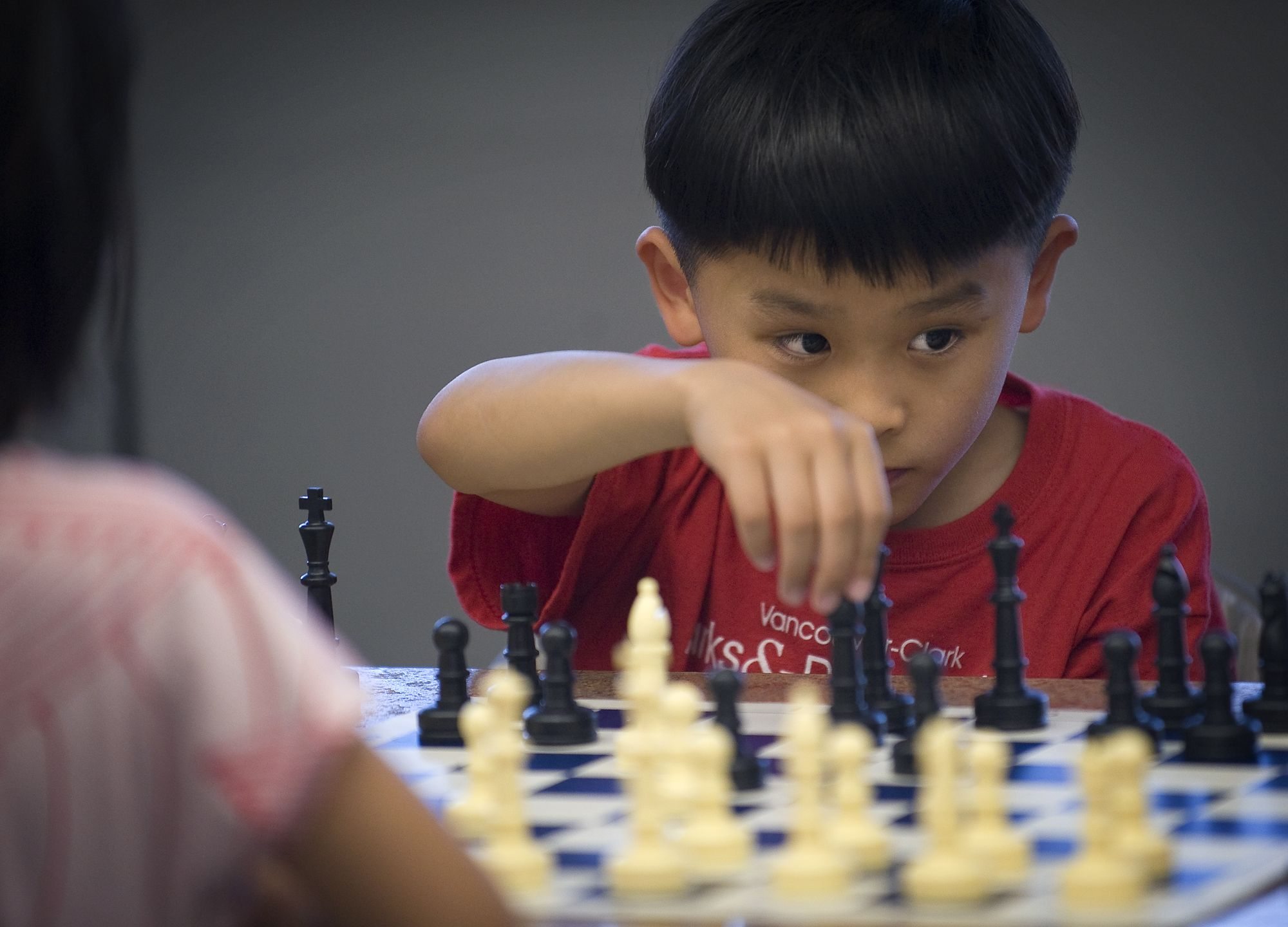 Jason Chang, 7, contemplates his next move while playing Plunder Chess against Alice Tang, 6, at EinsteinWise in east Vancouver.