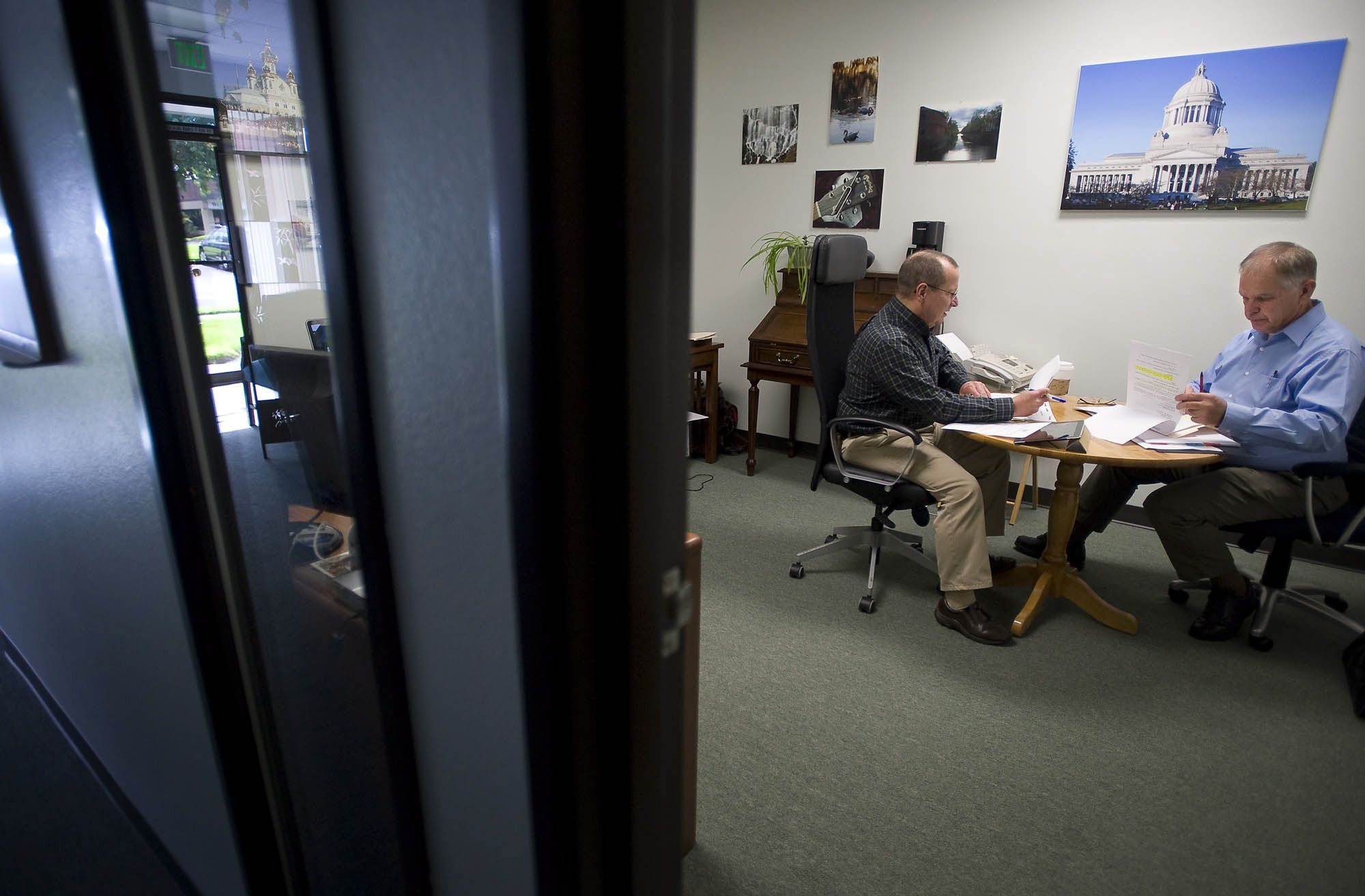 Photographer Tim Stewart, right, discusses his business plan with business adviser Buck Heidrick at the offices of the Small Business Development Center.