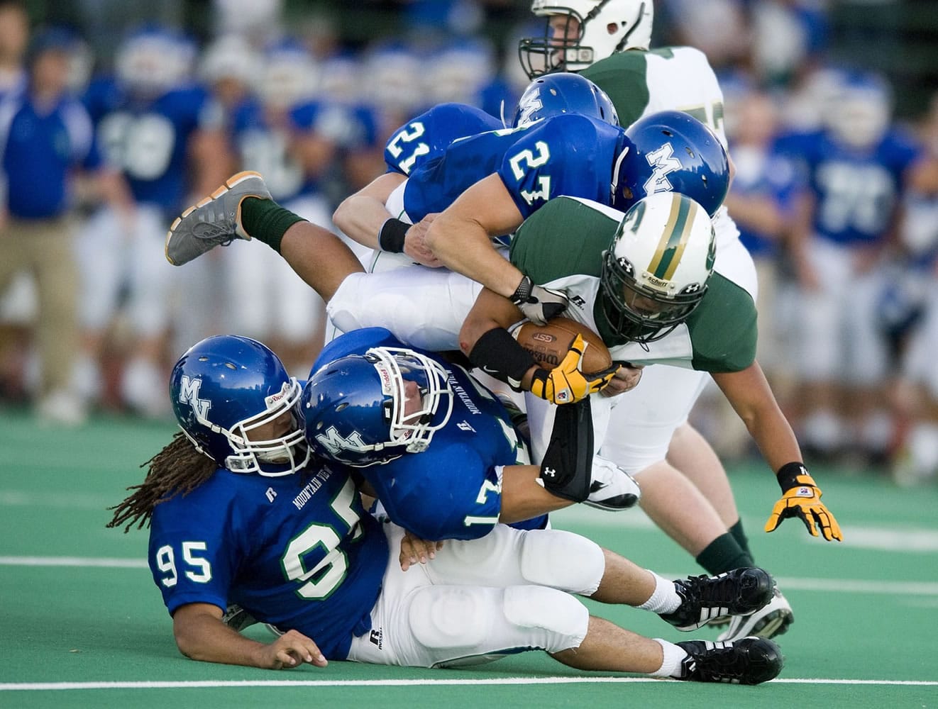Mountain View players get piled on as Evergreen running back Jared Telles is taken down during the first week of the 2011 season at McKenzie Stadium.