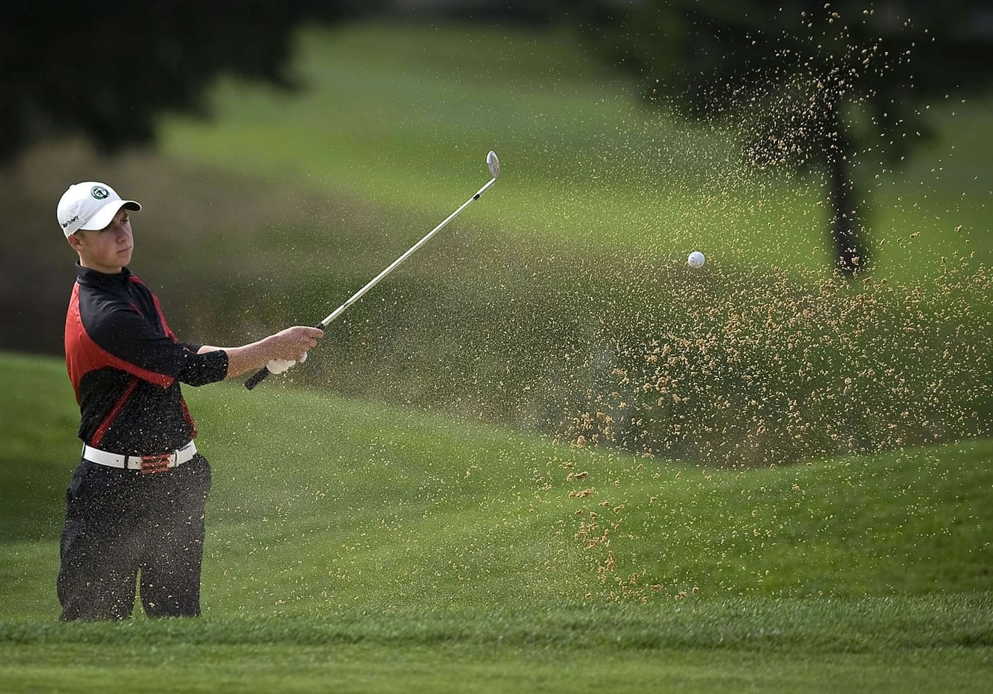Union's Alistair Docherty hits out of the bunker on the 18th hole during the final round of the Class 4A district golf tournament Wednesday at Tri-Mountain Golf Course in Ridgefield.
