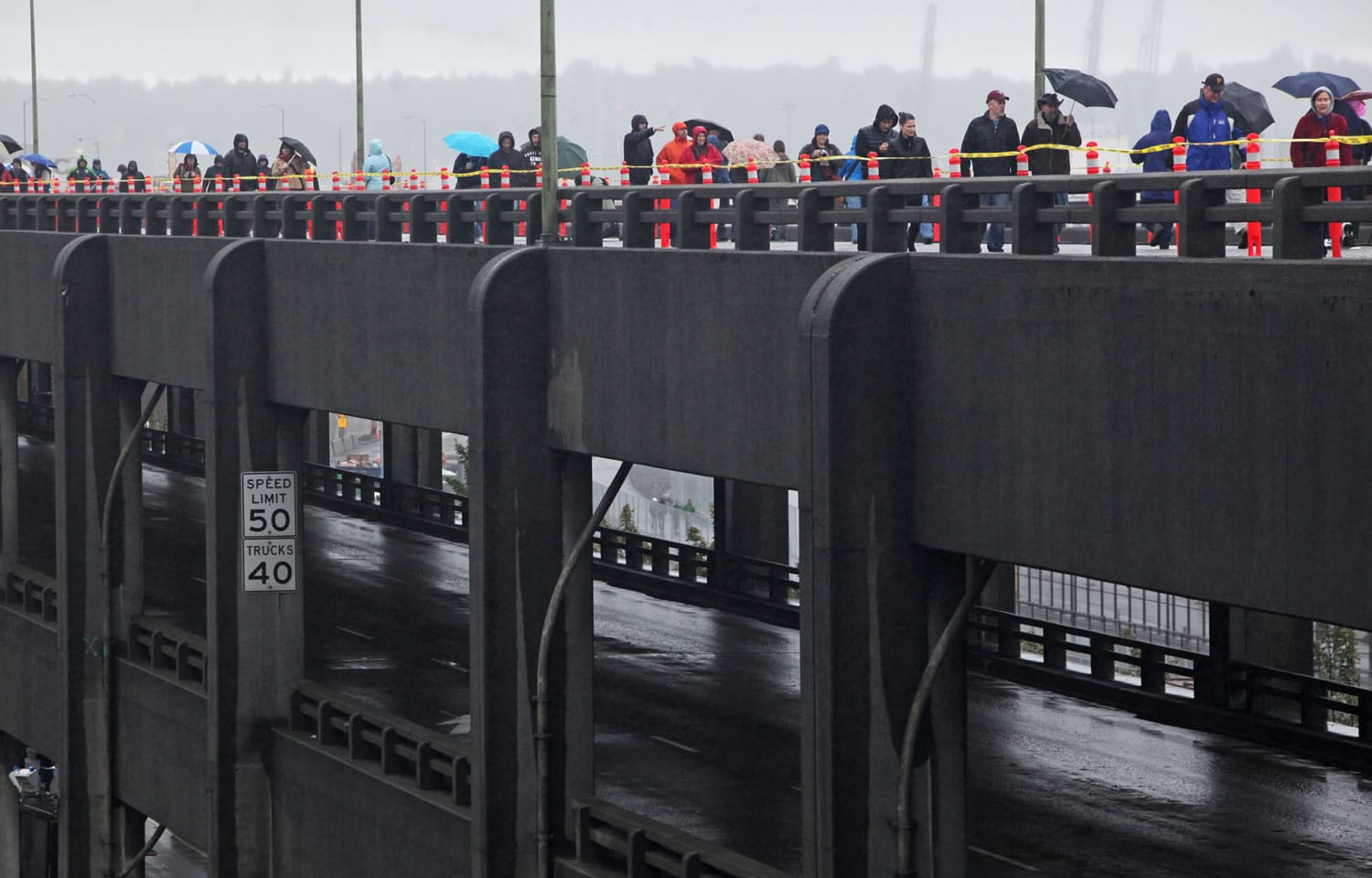 The public walks on the top deck of the Alaskan Way Viaduct near the stadiums Saturday morning in the rain.  They were able to to watch as crews demolished a section of the viaduct and also enjoy great views of the city from the structure that helped shape Seattle's waterfront.
