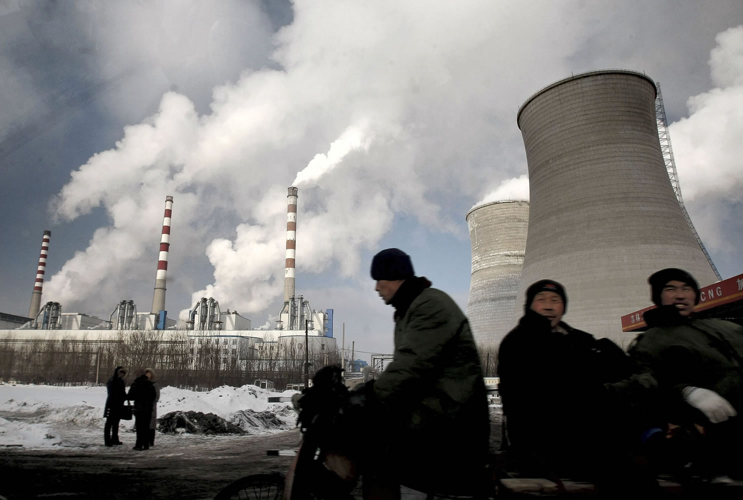 Workers cycle past a coal-fired power plant in December 2010 in Changchun, in northeast China's Jilin province. The world's emissions of heat-trapping carbon dioxide took the biggest jump on record, the U.S. Department of Energy calculated, a sign of how feeble the world's efforts are at slowing man-made global warming. The new figures for 2010 mean that levels of greenhouse gases are higher than the worst-case scenario outlined by climate change experts just four years ago.