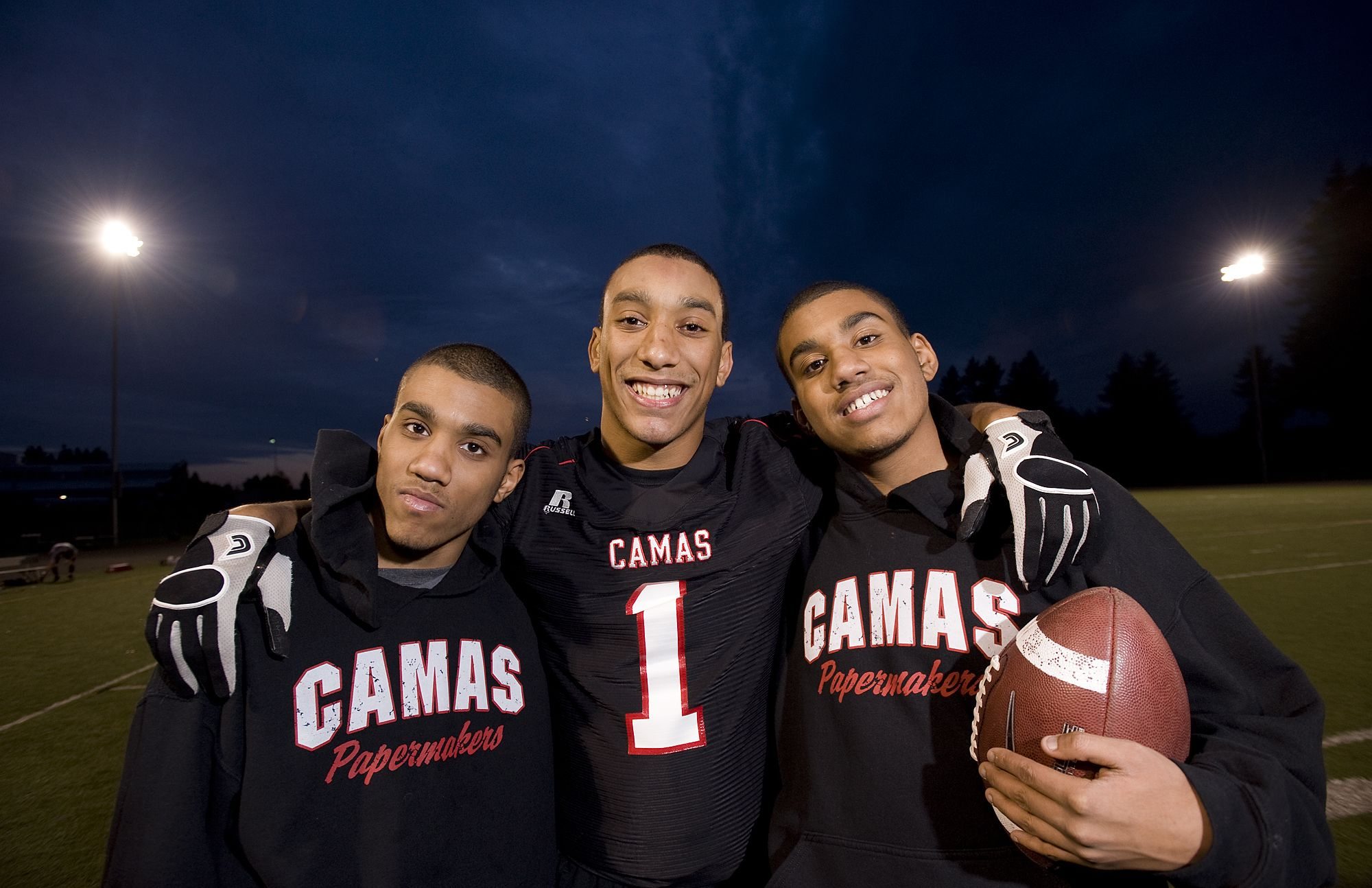 Jonathan Warner, center, poses with his autistic twin brothers, Christian, left, and Austin, at Camas High School.