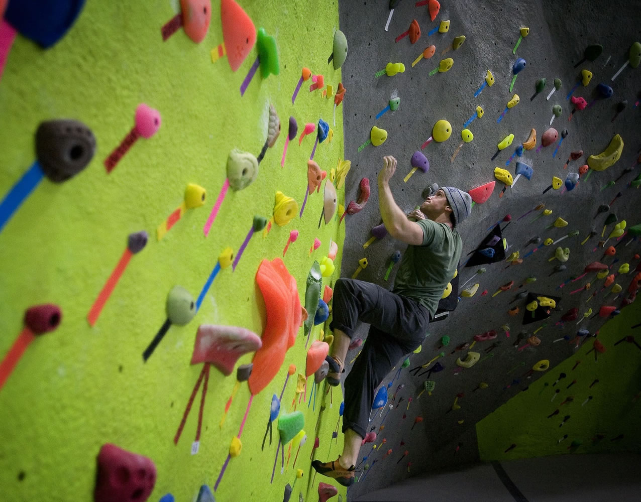James Carr, 25, of Vancouver climbs a rock wall Wednesday at a new fitness center ahead of its scheduled Friday opening.