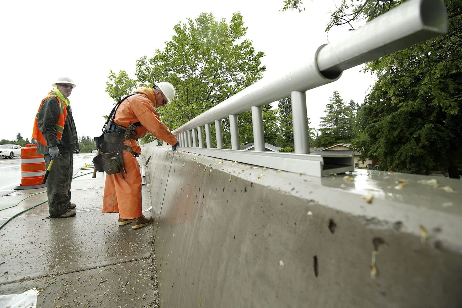 Construction workers Brad Wolf and Jeff Cummings of Zemek install pedestrian rails as work continues on the St. Johns Boulevard/state Highway 500 interchange project in Vancouver. Motorists on St.