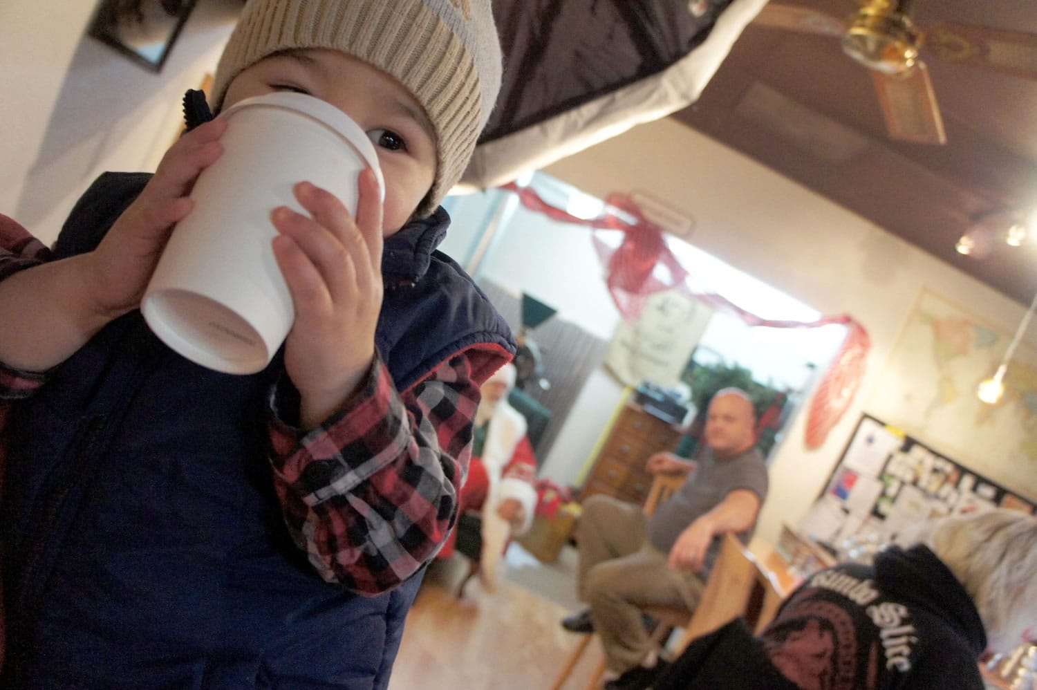 Edgewood Park: Henry Beagle, left, sips a drink under the watchful eye of his father, Andrew, second from right, and Santa Claus during an opportunity to meet Santa at Paper Tiger Coffee Roasters in Vancouver.