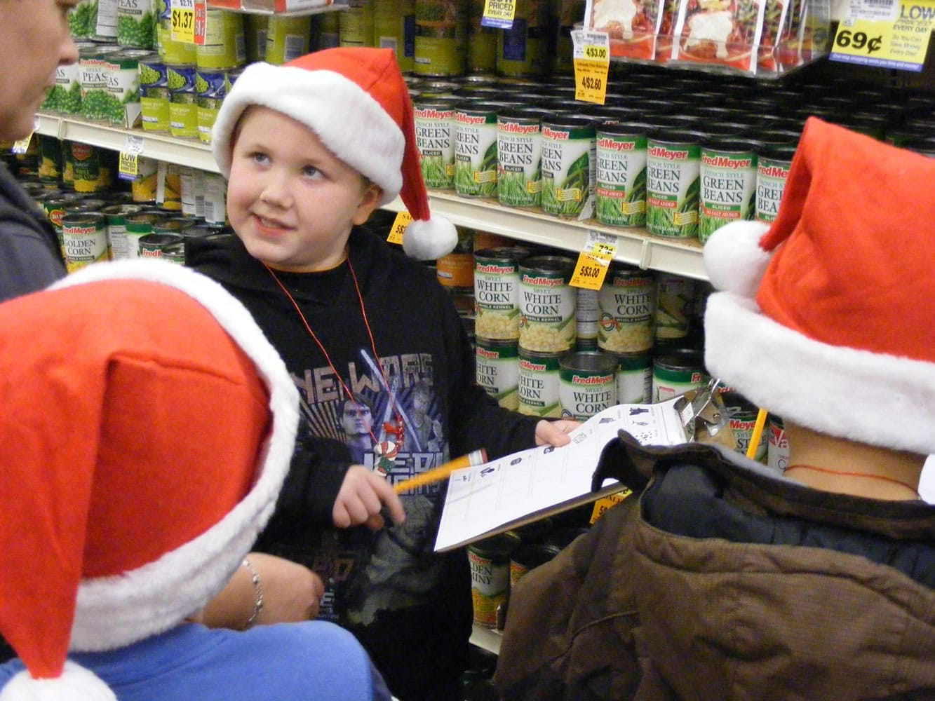 Battle Ground: Gabe Schmitendorf, 7, from Tukes Valley Primary, confers with teacher Kelly Gorby during a shopping trip for the North County Community Food Bank.