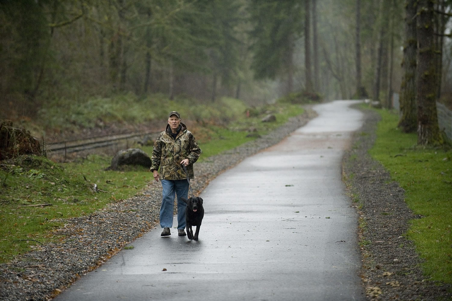 Ray Holbrook walks his dog, Pearl, on the new Chelatchie Prairie Railroad Trail near Battle Ground Lake State Park last week.
