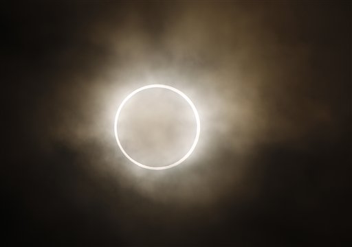 The moon slides across the sun, showing a blazing halo of light, during an annular eclipse viewed from a waterfront park in Yokohama, near Tokyo, on Monday. Millions of Asians watched as a rare &quot;ring of fire&quot; eclipse crossed their skies early Monday.