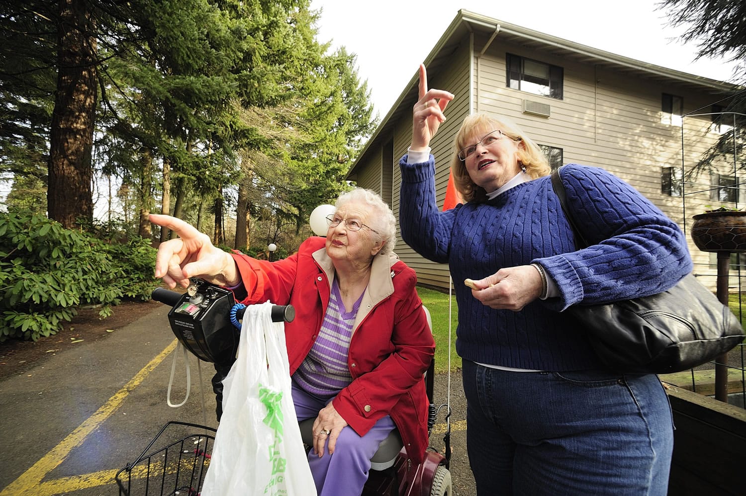 Pat Norby, right, and her mother, Jerry Sanford, 91, feed squirrels in a garden at Van Mall assisted living in Vancouver.