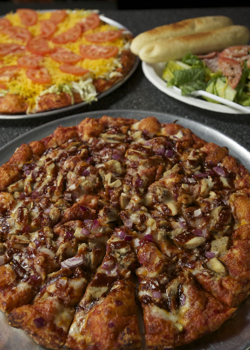 BBQ Chicken Pizza, clockwise from bottom, Taco Pizza and a dinner salad with breadsticks at Papa Pete's Pizza in Ridgefield.