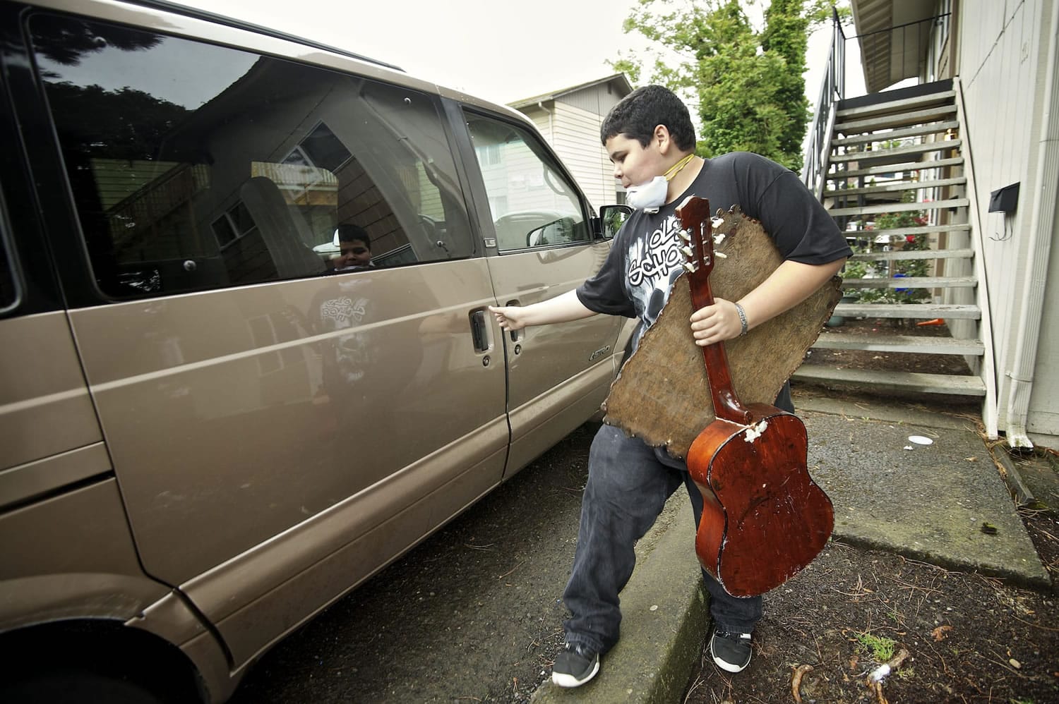 James Smith Jr., 13, loads cleaned items into a family van Thursday.