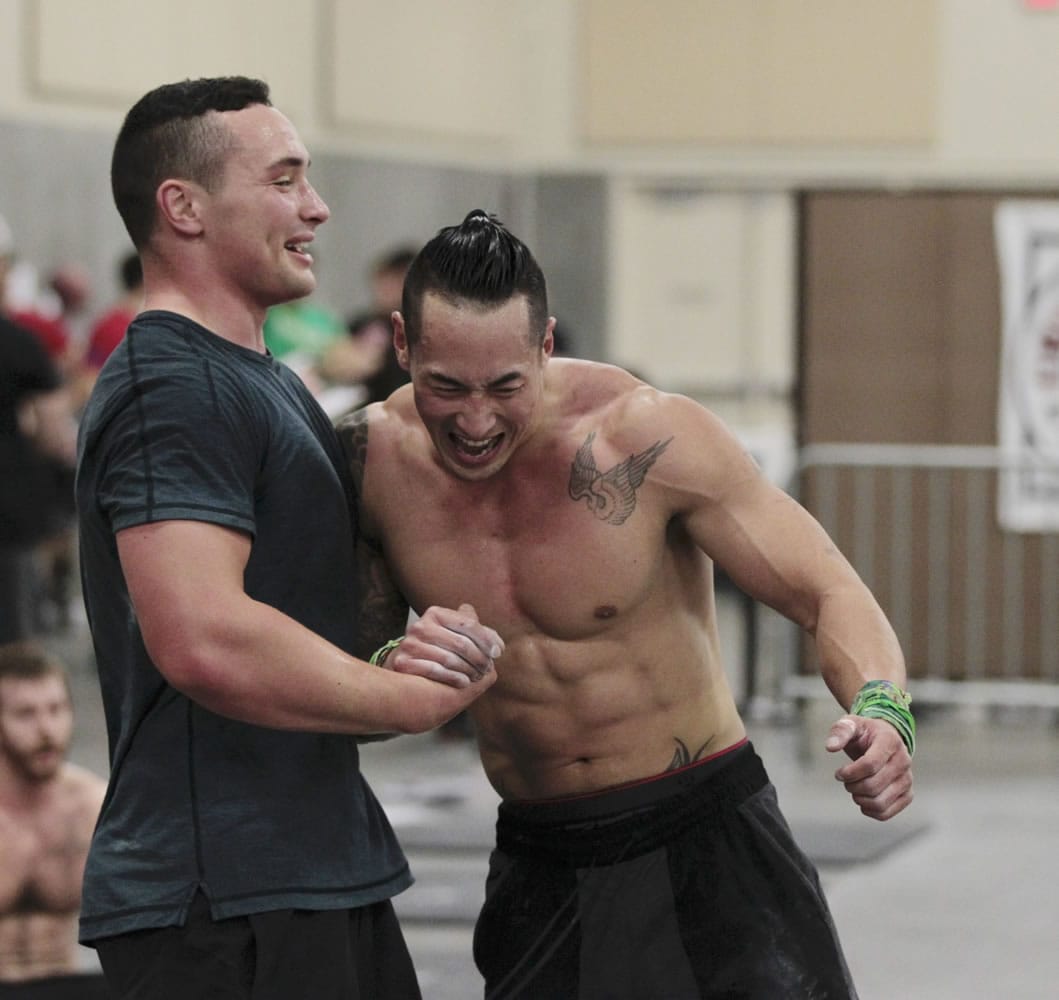Cameron Pernich, left, of Gresham, Ore., and Sun Chang react to being first to cross the finish line during one of the events Sunday at the CrossFit Fort Vancouver Championship at the Clark County Event Center at the Fairgrounds. Pernich described Chang, from Boise, Idaho, as his workout mentor.