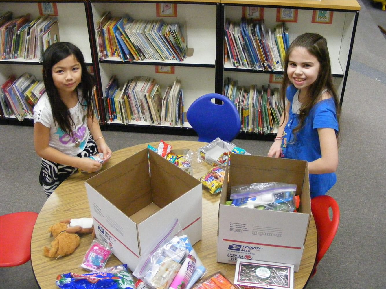 Battle Ground: Ashton Daniels, left, and Erin Brady, fourth-graders at Maple Grove Primary School in Battle Ground, pack boxes destined for U.S.