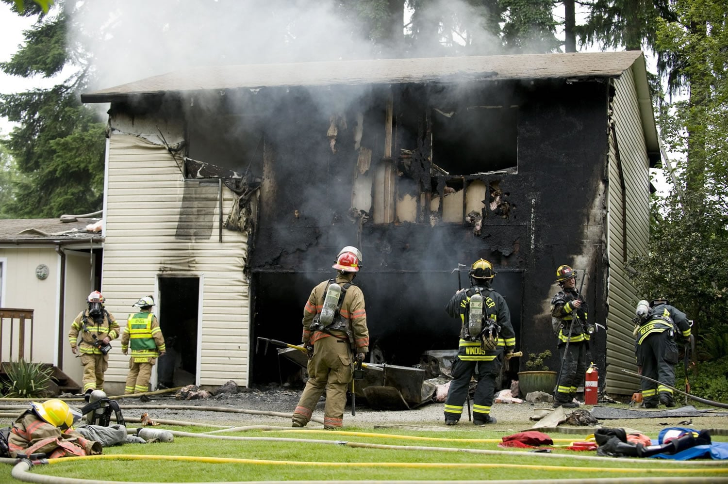 Flames escaped as the door warped on this garage, spread up the vinyl siding and entered the rooms above.