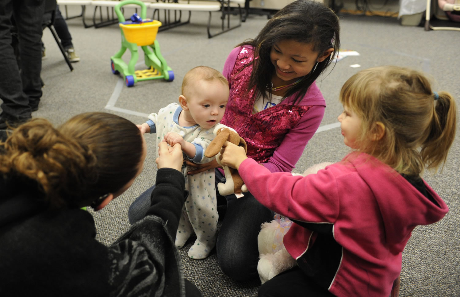 Four-month-old Zylander Studer is the center of attention for Mai Truong, center, Madelyn Ackerman, right, and mom Querida Yerkes, left, during a Second Step parenting class.