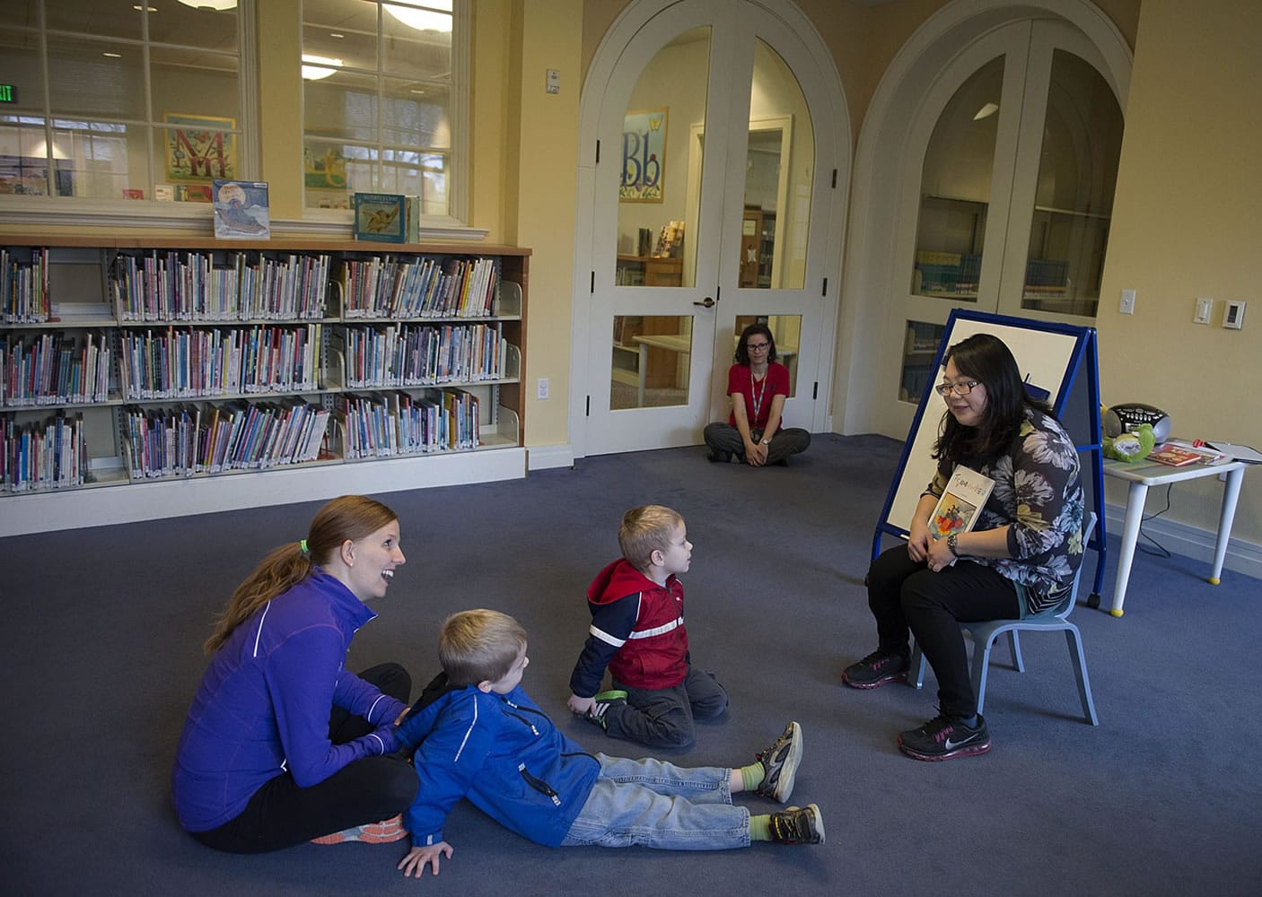 Ondalynn Vance, from left, of Vancouver enjoys Chinese Storytime with her sons, Isaac, 5, and Paxton, 3, as volunteer Amber Huang reads a book at the Camas Public Library. City officials are deciding whether the library should remain independent from the Fort Vancouver Regional Library District.