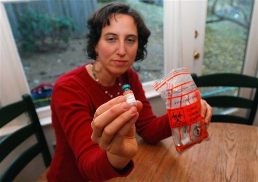 Sitting in her home in Ashland, Ore., Jennifer Margulis shows off empty vials of vaccine that she saves in case one of her children has a bad reaction.