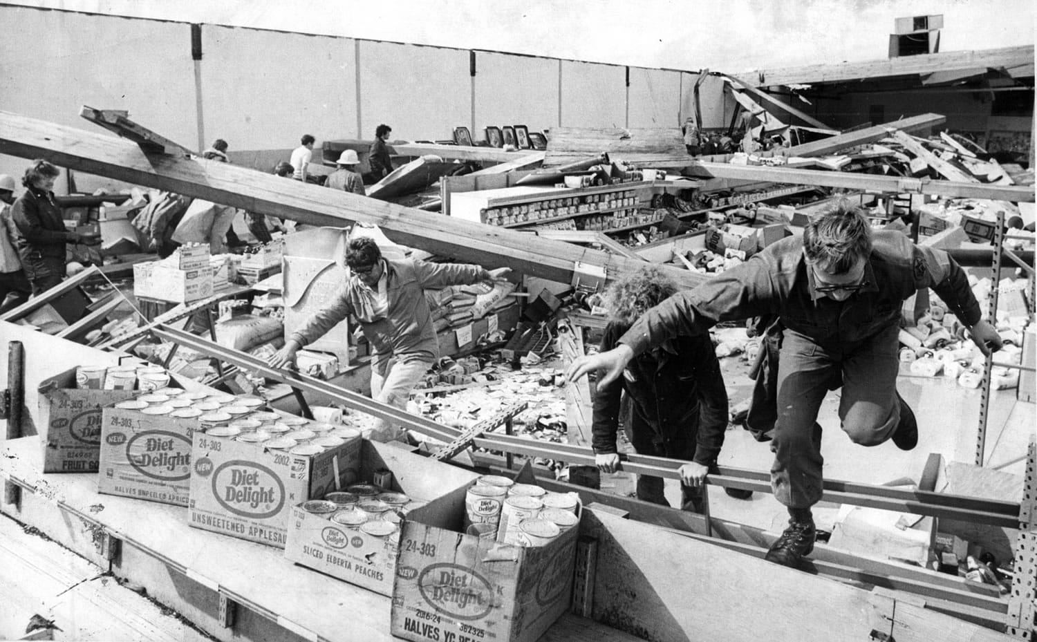Searchers race in and out of the demolished Waremart store, where five people were killed in Vancouver on  April 5, 1972.