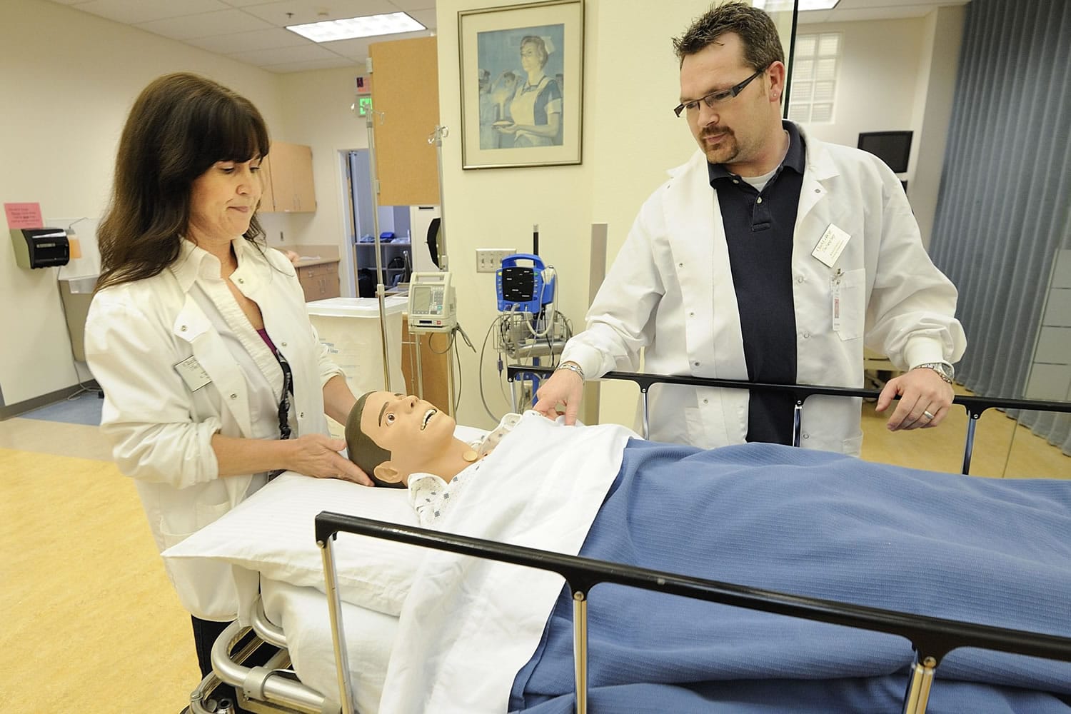 Kati Kleiser, left, a lab instructor at Clark College's nursing program, and Kris Fowell, a nursing department technician, examine &quot;Fred,&quot; a Sim mannequin Kleiser used when she herself was a student in the program 10 years ago.