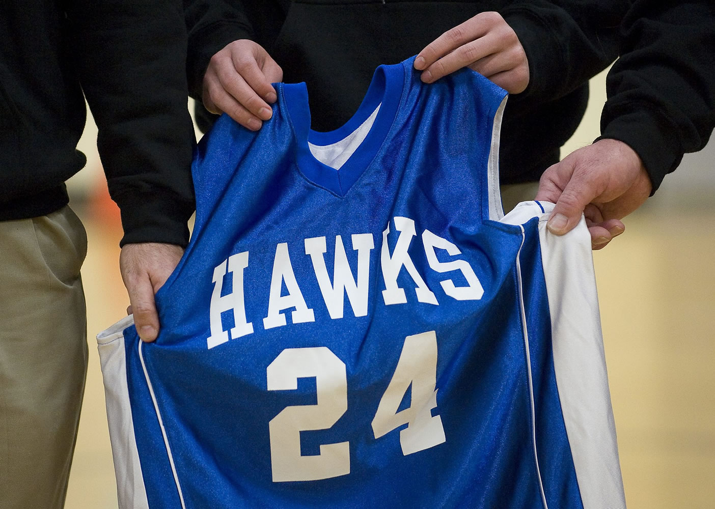 Members of La Center Middle School's basketball coaching staff hold the jersey of Cody Sherrell during a ceremony honoring the boy Thursday inside the school's gym. Cody died Jan.