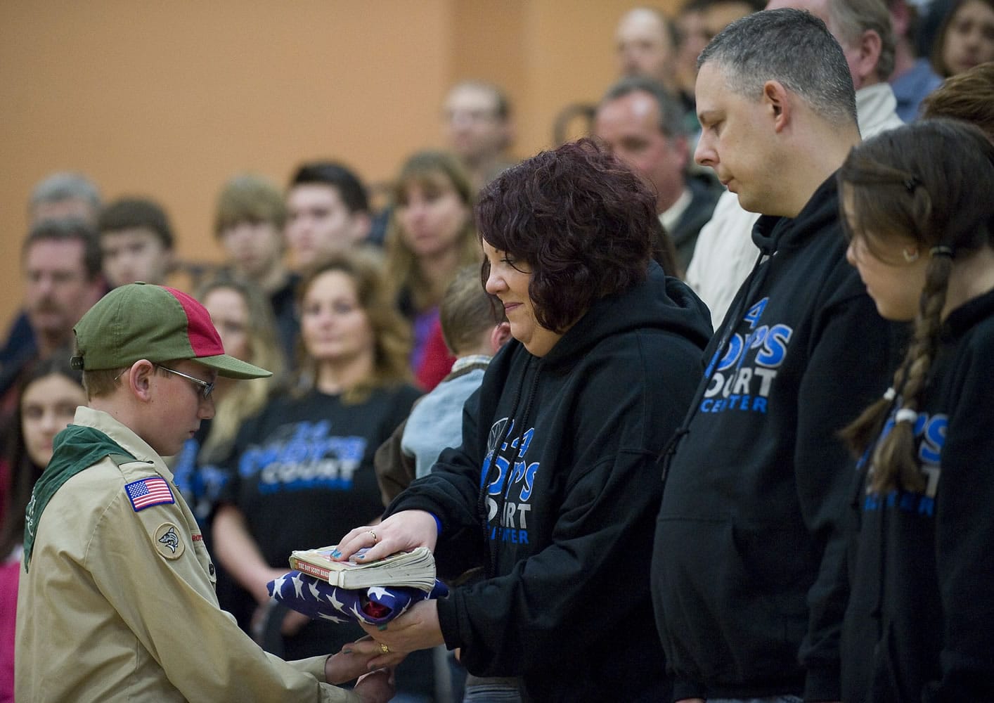 Boy Scout Troop 484 member Scott Brightbill, 13, hands Renee Sherrell, mother of Cody Sherrell, a U.S. flag during a ceremony in Cody's honor Thursday inside the La Center Middle School gym.