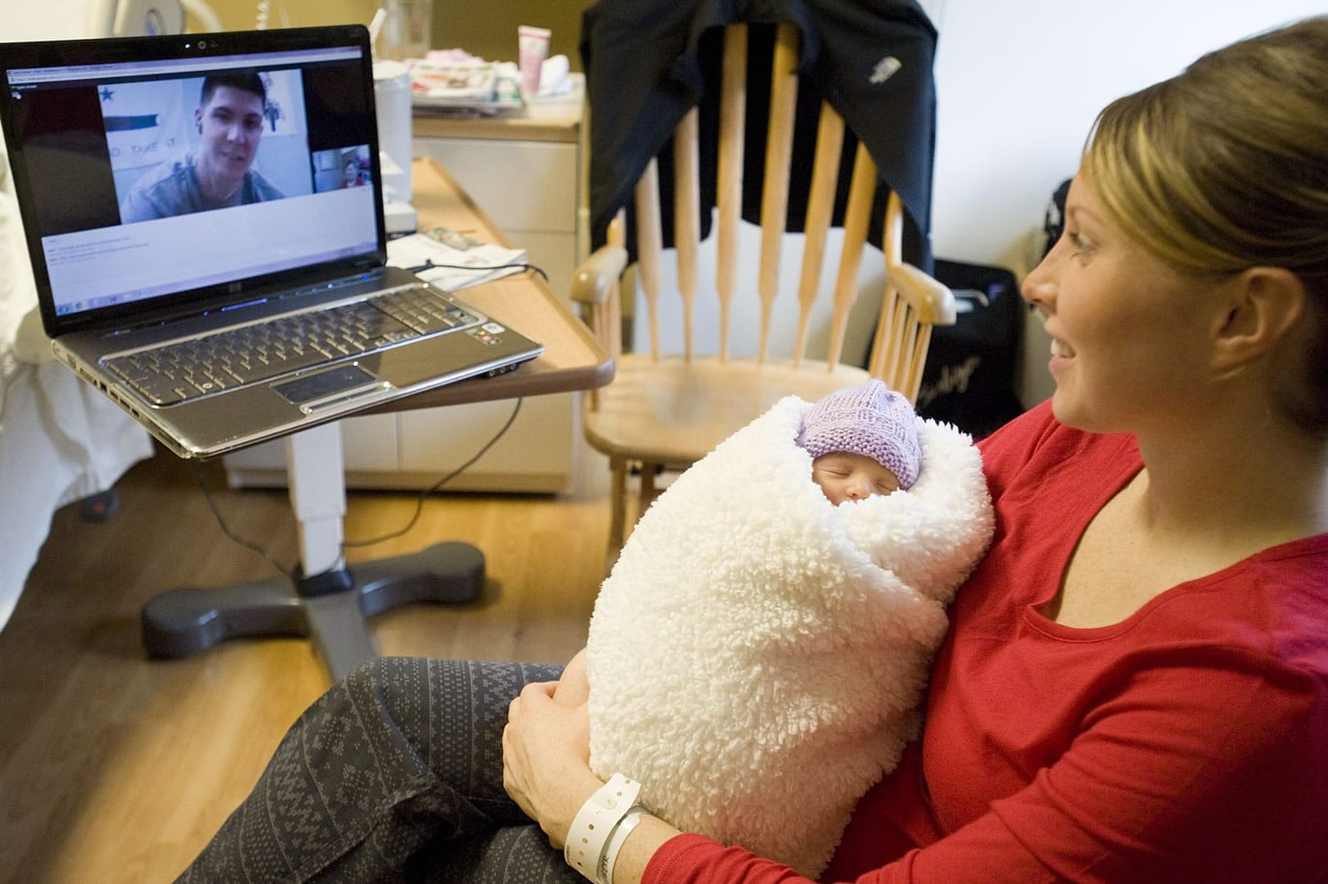 Robbie Mose holds her newborn daughter, Stella, as she talks with her husband, Ryan, via webcam Saturday. Army Staff Sgt.