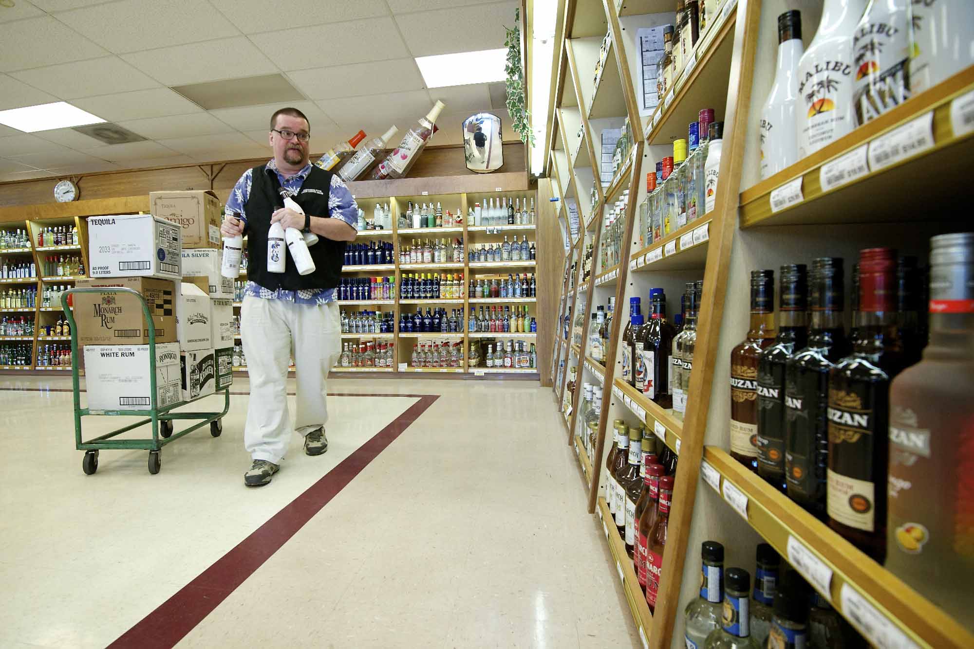 Eric Simonson stocks liquor shelves at a State owned liquor store, #10, one of the oldest stores in the system, Monday in Vancouver