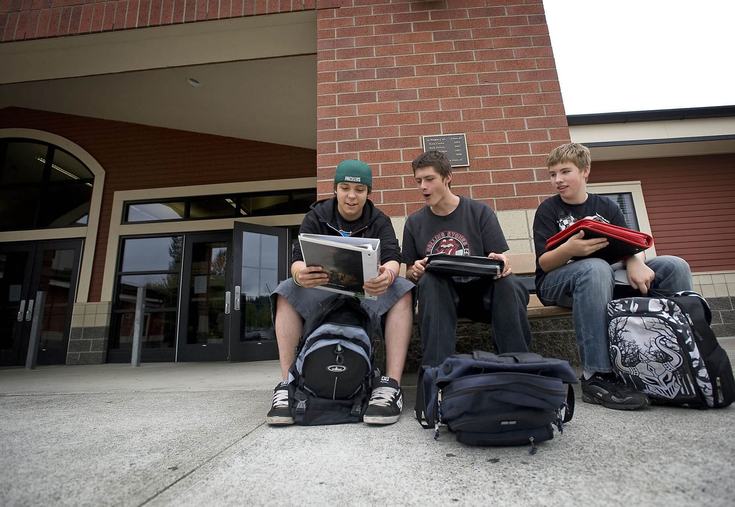Washougal High School sophomores, from left, Alex McCabe, 15, Hector Morales III, 16, and Austin Milton, 15, compare folders on the first day of school on Tuesday.