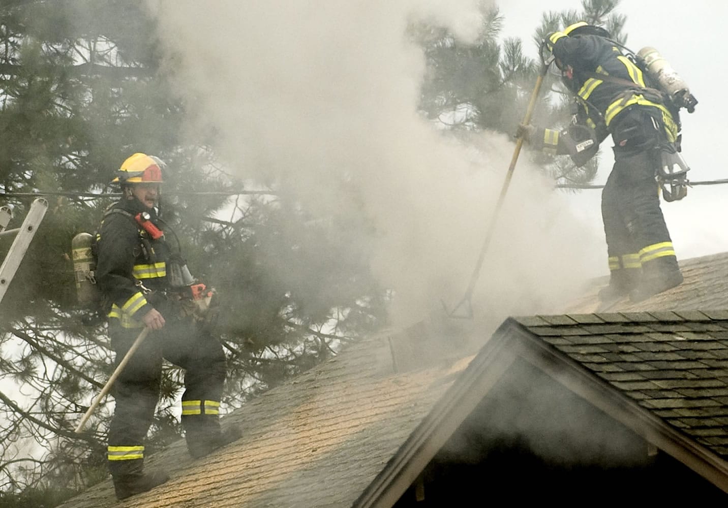 Firefighters cut a 4-foot-square vent hole in the roof of a burning building at 3509 N.E.