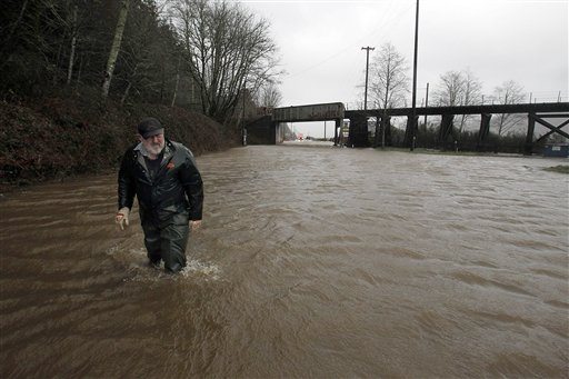 Dick Fithian makes his way through the Siuslaw River floodwater in Cushman, Ore., three miles East of Florence, Ore. Thursday morning Jan. 19, 2012. Fithian lives on on the other side of the flooding and was walking about a mile in waders to get picked up by his wife. They were planning to stay in Florence.