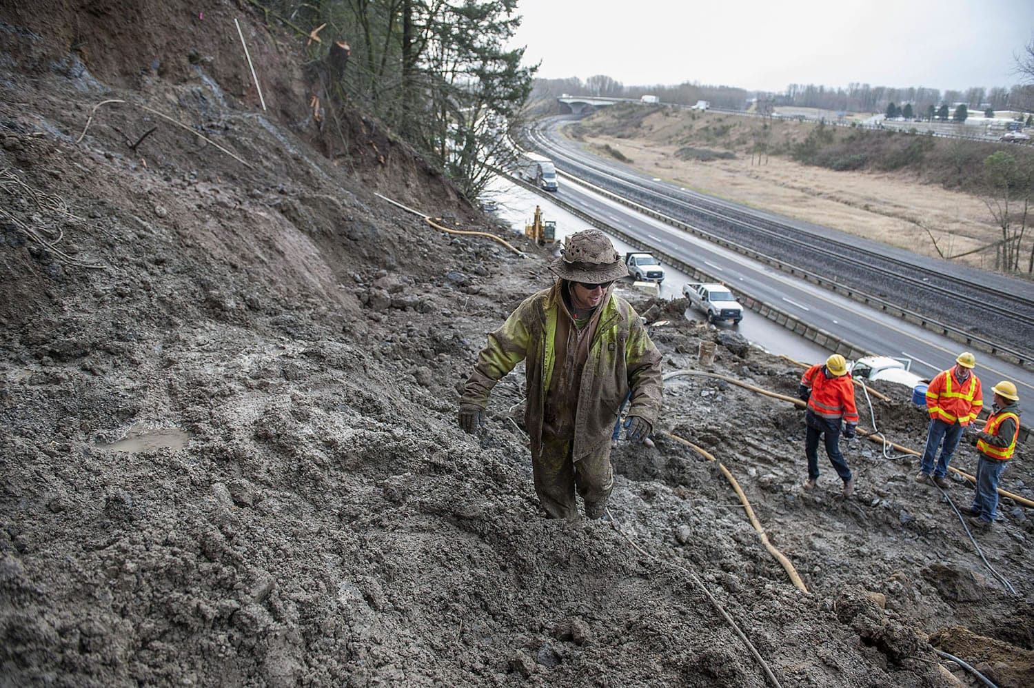 Jon Simpson of Access Limited Construction navigates through thick mud while working along the side of Interstate 5 on Friday morning near Woodland.