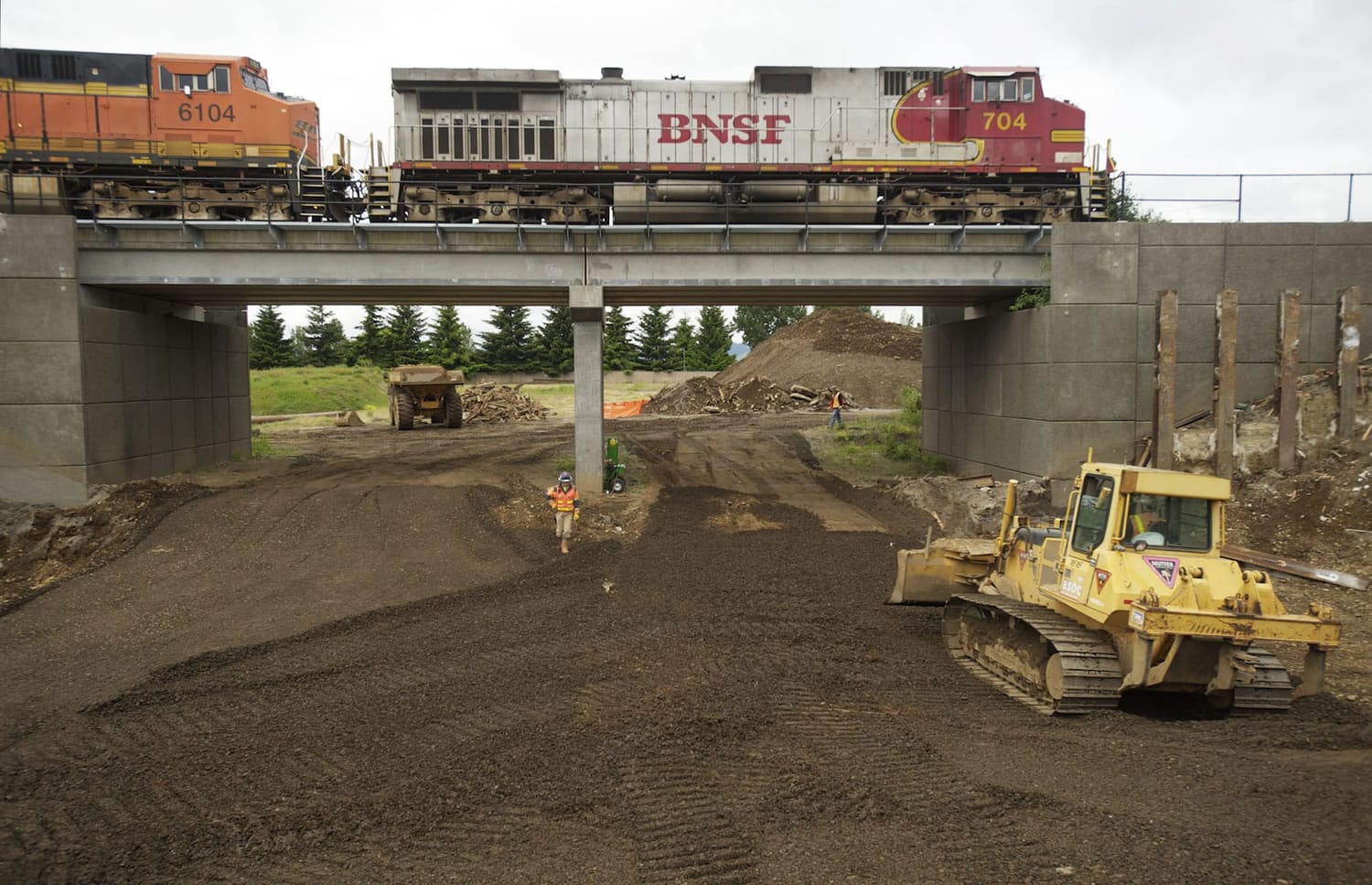 Construction continues clearing a passageway to the Columbia River waterfront through the BNSF Railway berm at the south end of Esther Street on Wednesday.