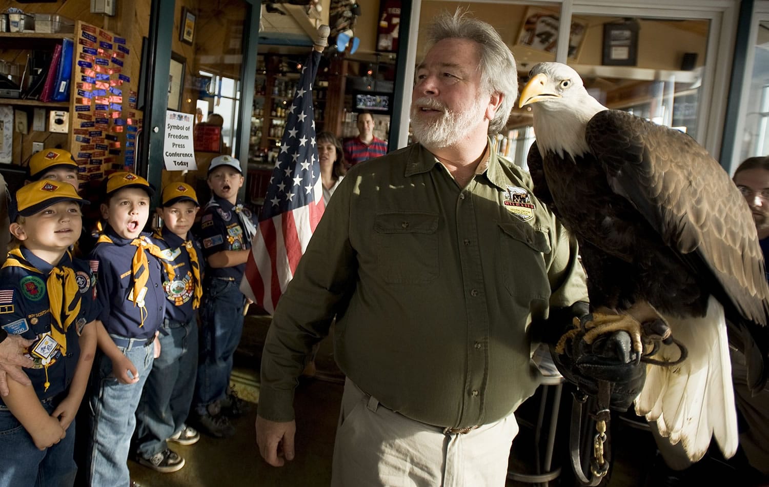 Members of Cub Scout Pack 443 from Battle Ground are impressed Wednesday afternoon as David Siddon and bald eagle Defiance enter Beaches Restaurant for an event leading up to Veterans Day observances.