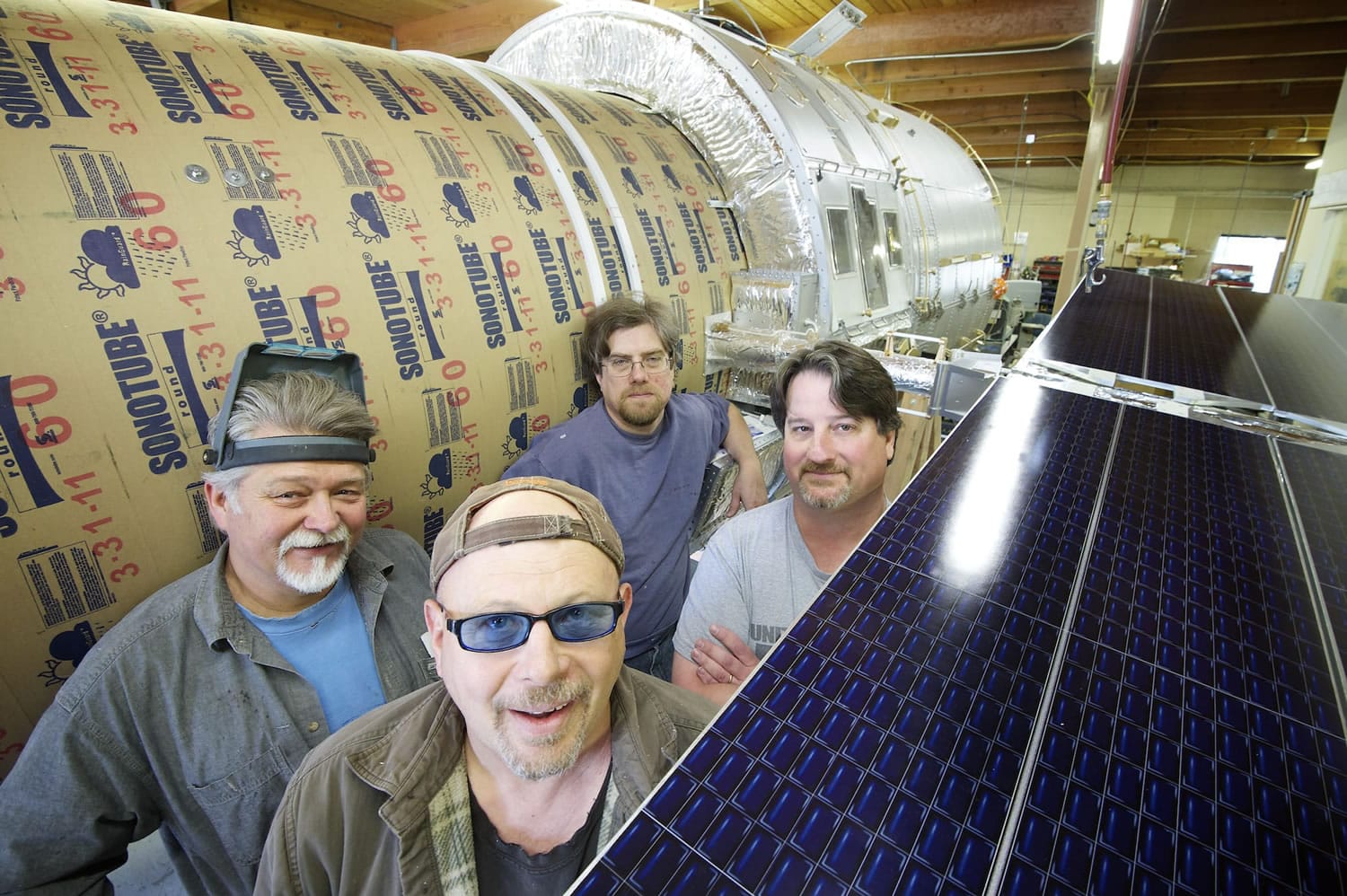 From left to right: model makers Ed Warmack, Matt Kilwein, Robert Willard, and John Geigle, owner of Masterpiece Models, stand next to a model of Hubble Wednesday June 6, 2012. Model makers are working on building a half-scale replica of Hubble Telescope for the Museum of Flight in Seattle.