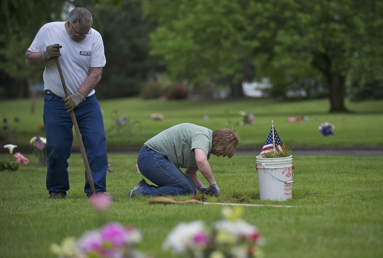 Warren and Sharron Wannmaker of the Burnt Bridge Creek neighborhood tend to the graves of Sharron's dad, Gene Lusby, grandfather and grandmother at Park Hill Cemetery on Sunday.