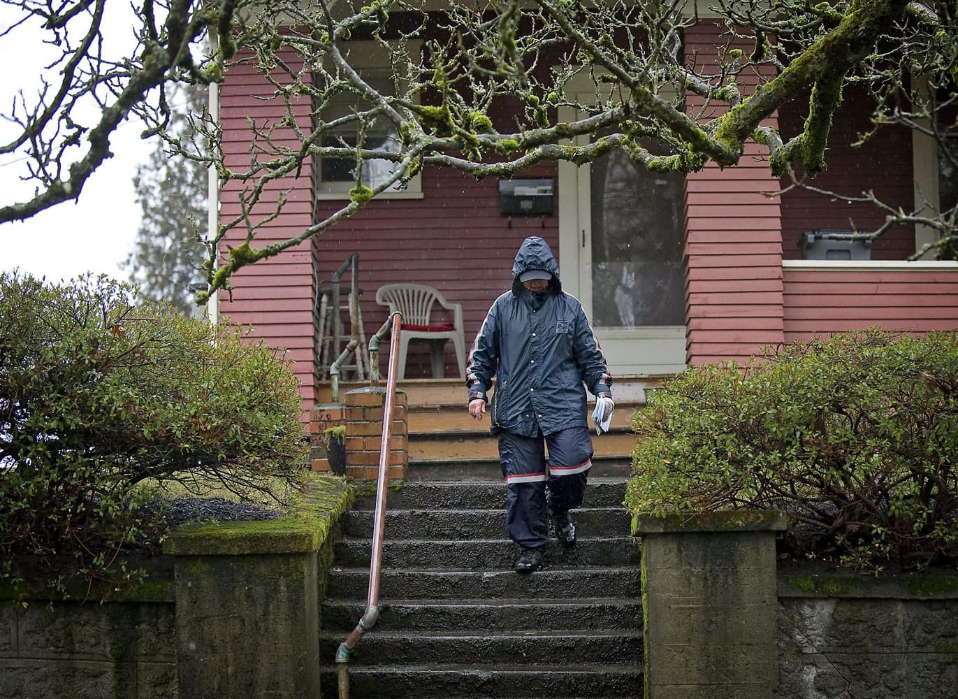 A mail carrier walks down steep steps after delivering mail to a home on West 21st Street in the Hough neighborhood.