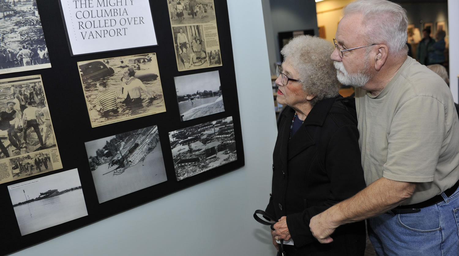 Luanne (Wolfe) Barnes, a survivor of the 1948 Vanport Flood, looks at old photos with her husband, Ed Barnes, at Saturday&#039;s opening of the Vanport Flood Exhibit at the Water Resources Education Center in Vancouver.