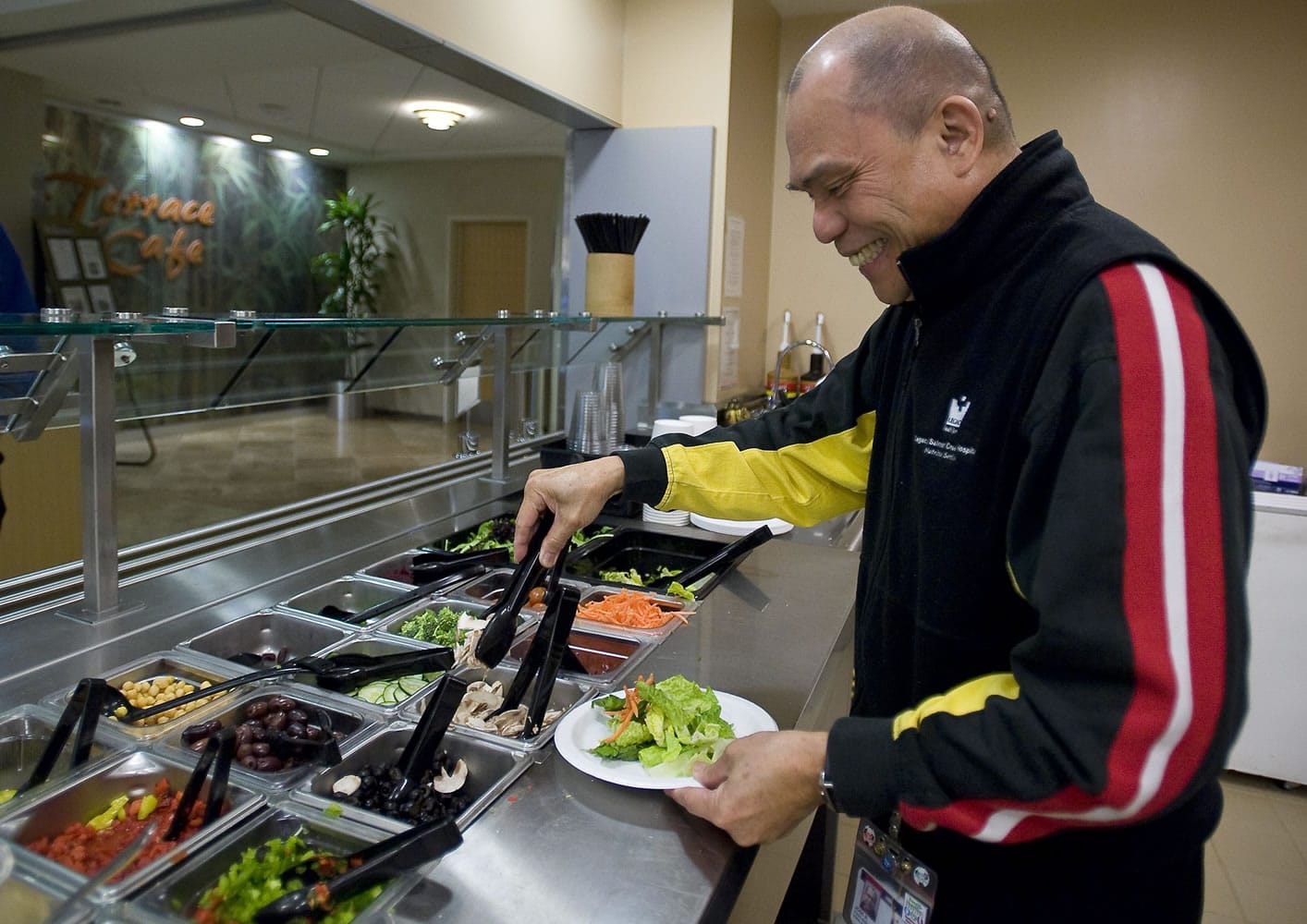 Jose &quot;Joe&quot; Red, 65, makes a salad for lunch on Wednesday while taking a break from his job as lead cashier in the Legacy Salmon Creek Medical Center cafeteria.