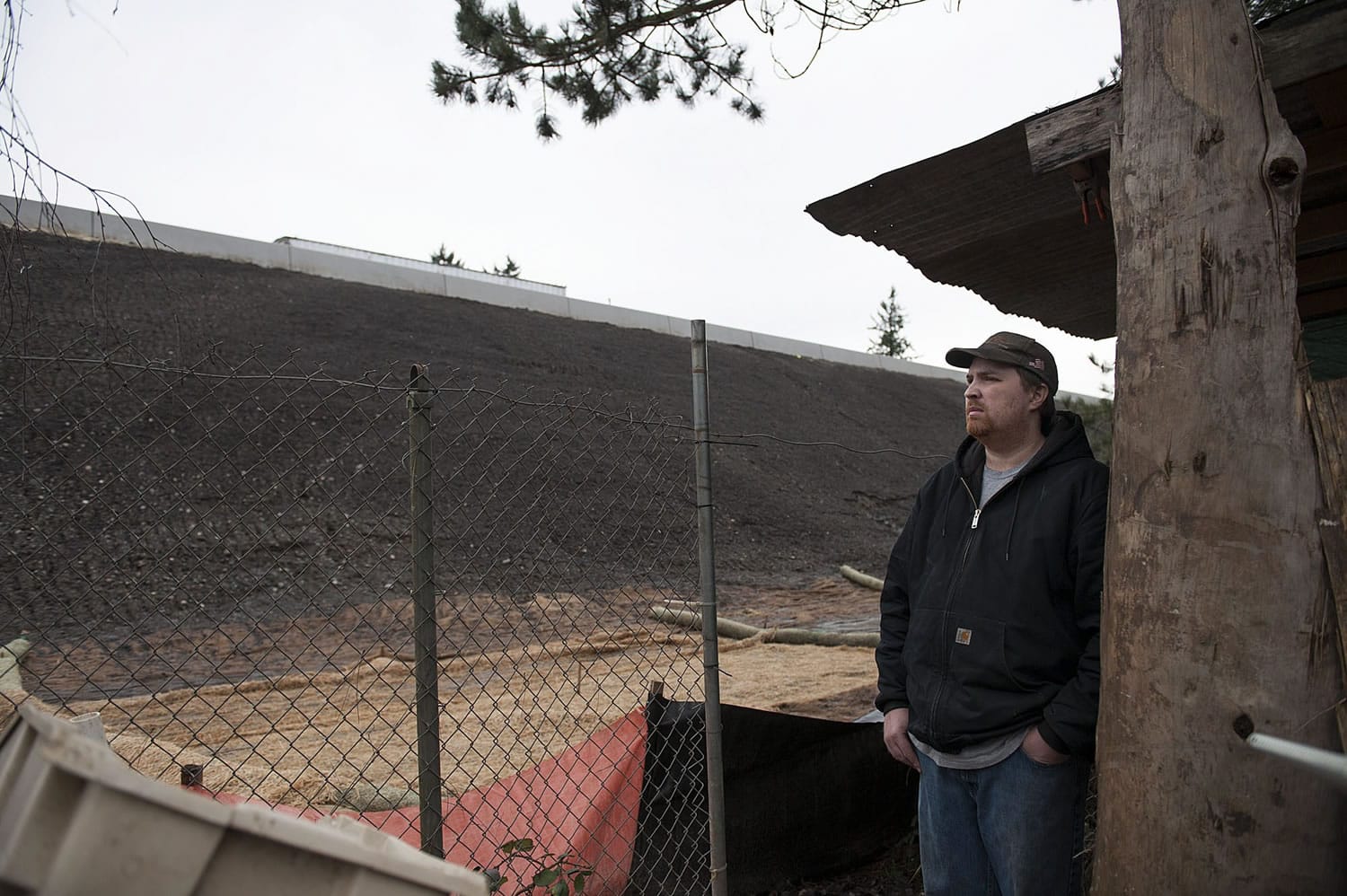 Steven Hoard of Vancouver looks up at the hillside between his backyard and the southbound lanes of Interstate 205. The hillside used to be full of trees, bushes and other brush that muffled the freeway sounds and stabilized the slope, but the state cleared the area to make way for interchange improvements.